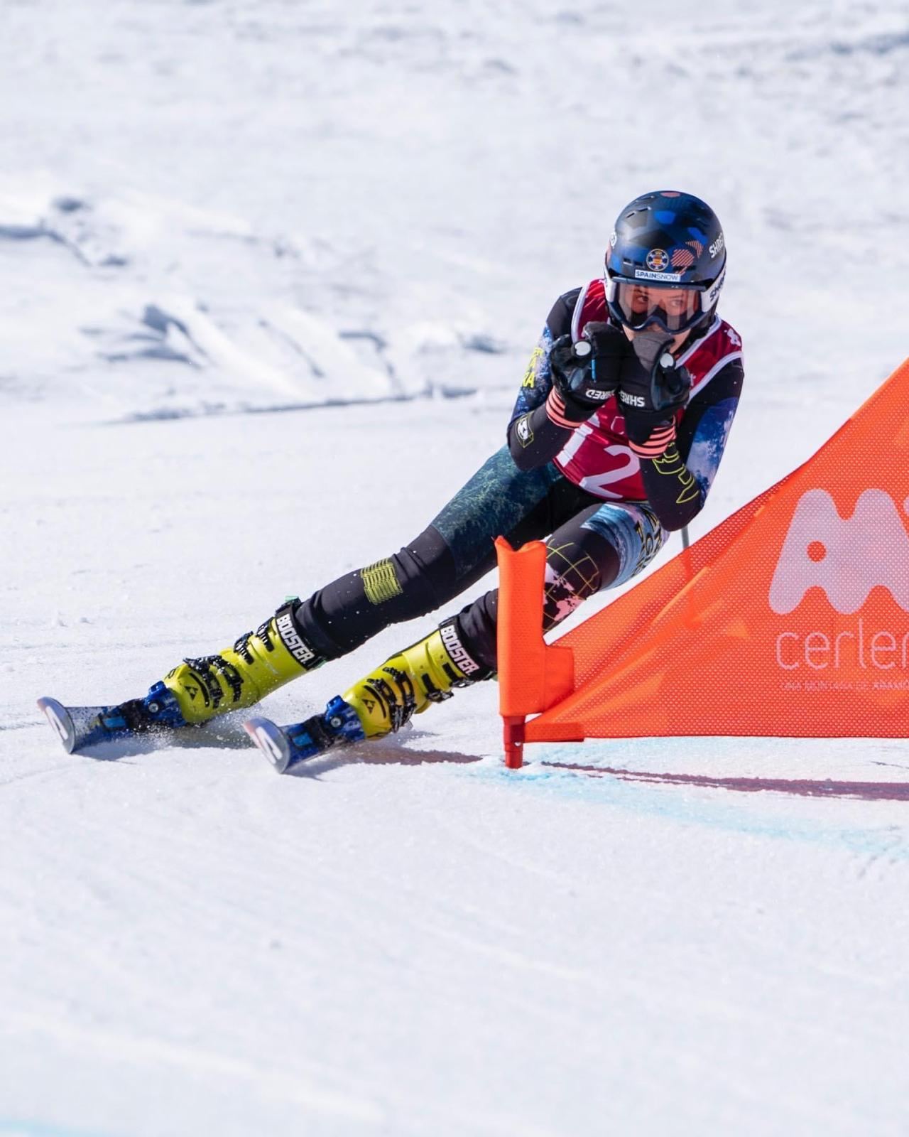 Deportista del grupo U14/U16 toma un giro junto a una puerta de skicross en Cerler.
