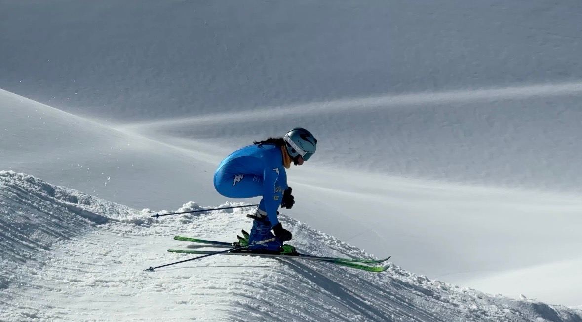 Tres corredores de skicross salen de un peralte, con el público detrás.
