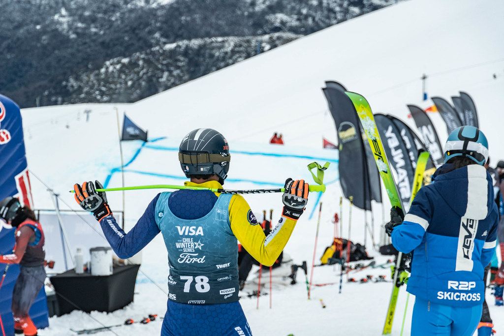 Un corredor con el dorsal 78 espera en la zona de salida, junto a un miembro del equipo con la chaqueta de R2P Skicross.
