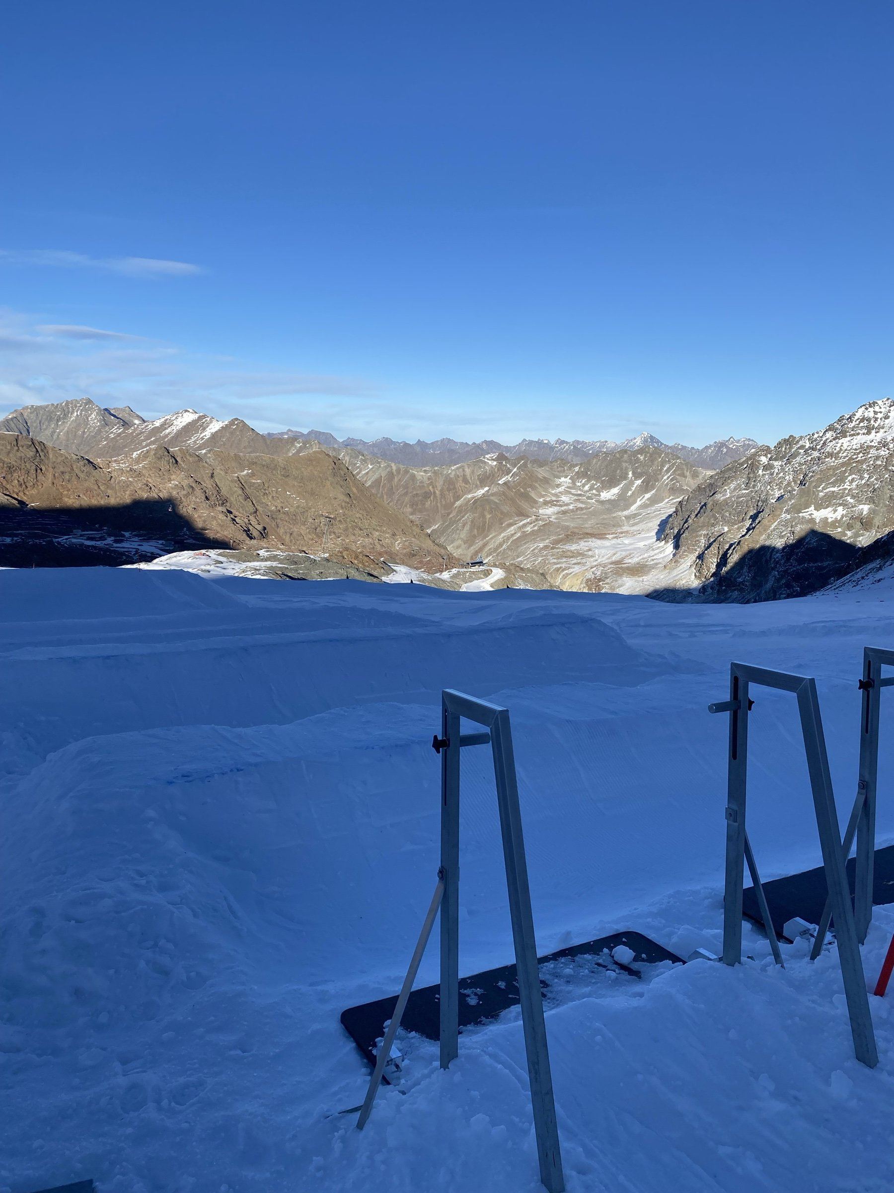 Puertas de salida del circuito de skicross de Pitztal al amanecer, con el valle y las montañas al fondo.