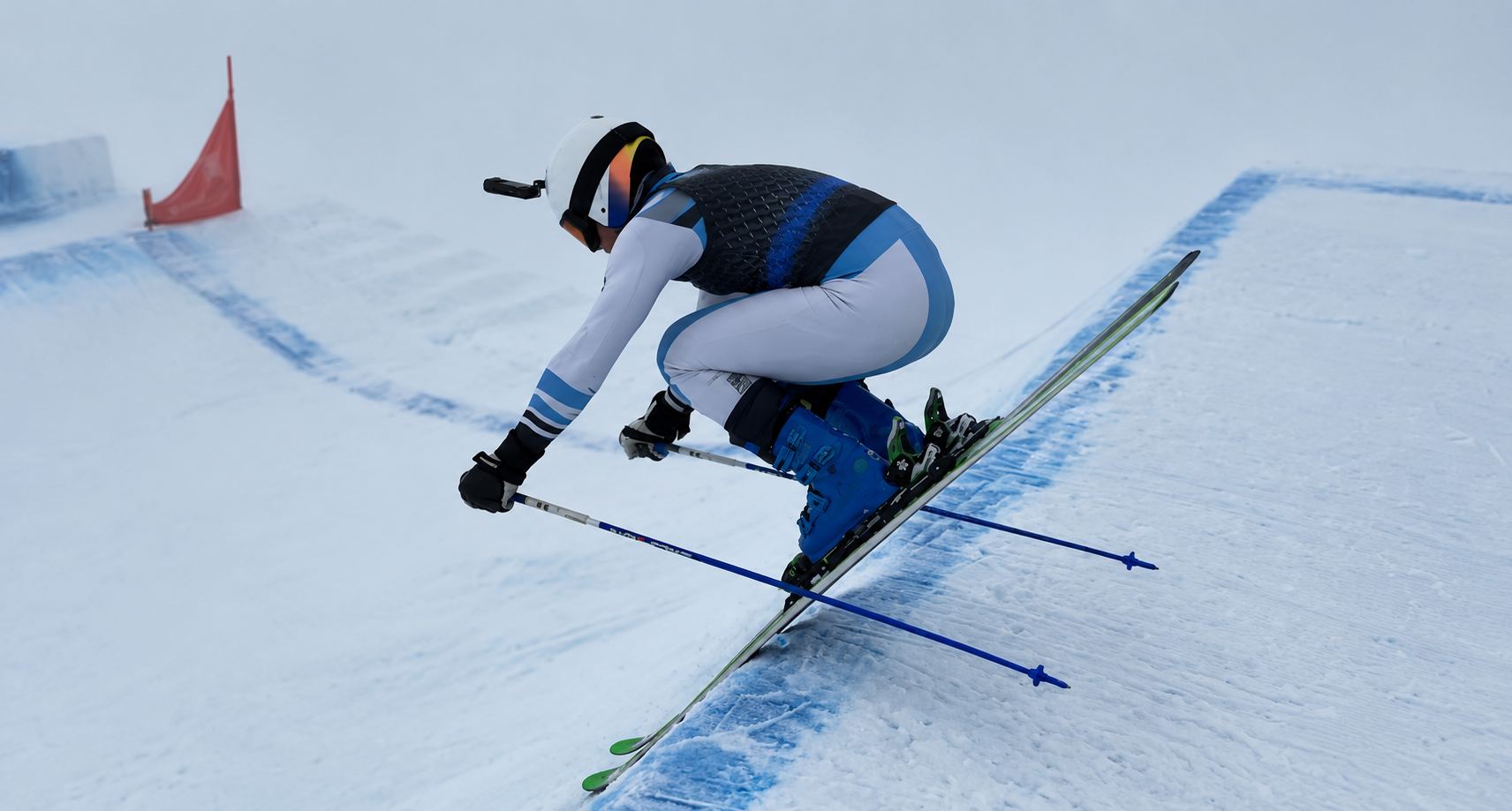 Un corredor de skicross toma un peralte agachado, con la niebla de fondo.