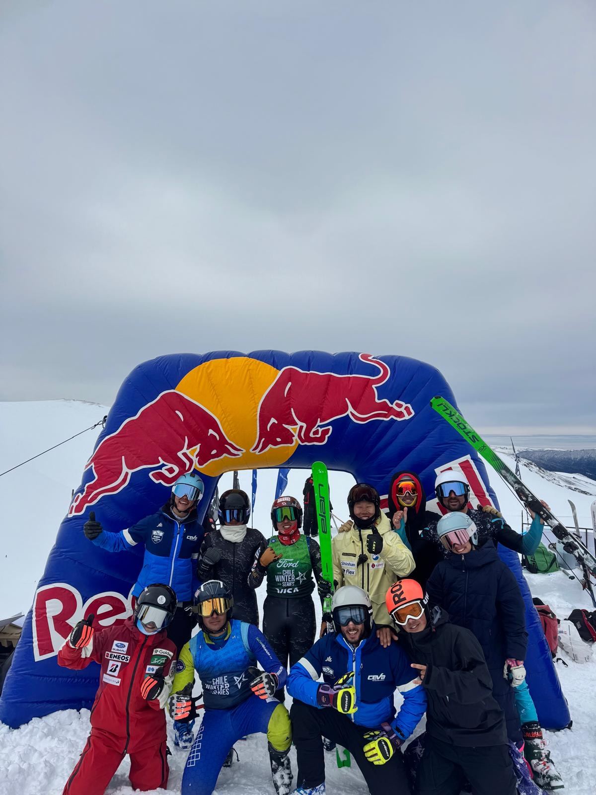 El grupo de un stage posa en la nieve bajo un arco hinchable, con los esquís en alto.
